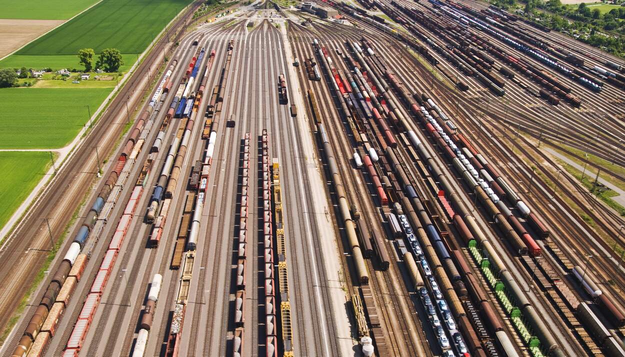 Flere titalls jernbaneskinner med godstog sett ovenfra